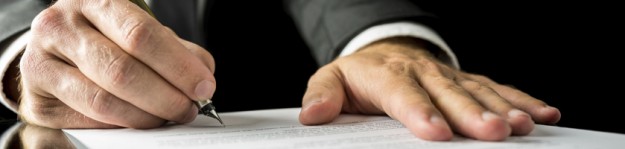 Businessman signing a paper document