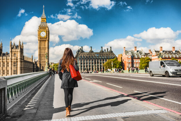 London city urban lifestyle tourist woman walking. Businesswoman commuting going to work on Westminster bridge street early morning. Europe travel destination, England, Great Britain, UK