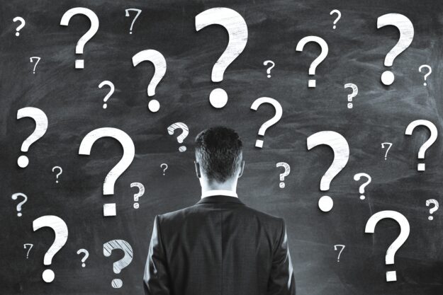 A,Person,In,A,Business,Suit,Faces,A,Chalkboard,With