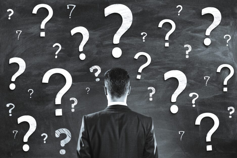 A,Person,In,A,Business,Suit,Faces,A,Chalkboard,With